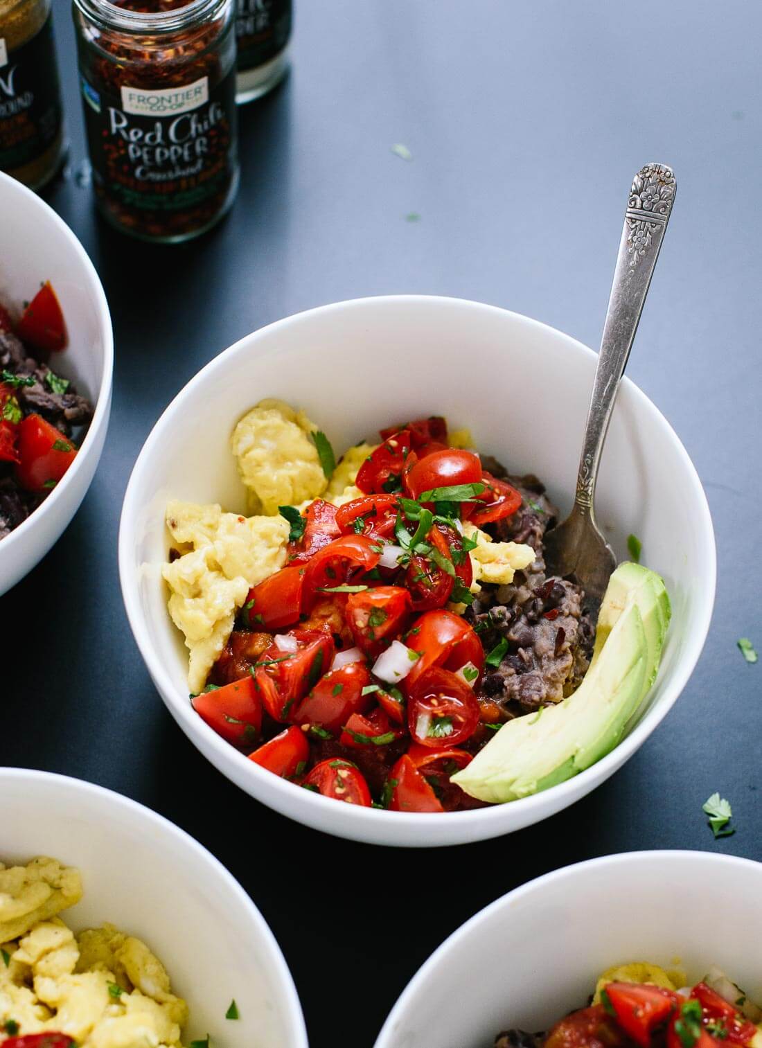 Delicious breakfast bowls made with scrambled eggs, black beans, pico de gallo and sliced avocado! cookieandkate.com