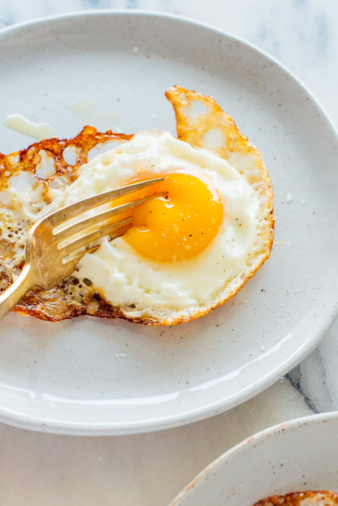 crispy fried egg oozing under fork