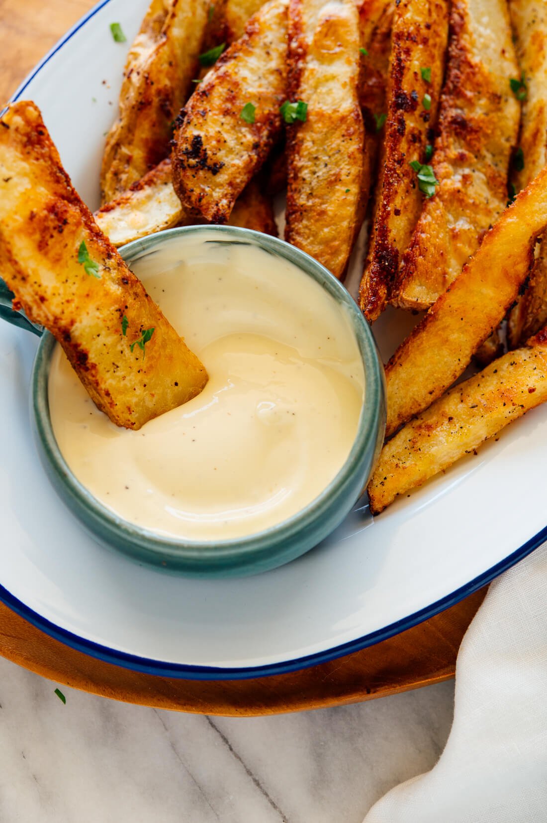 crispy potato wedge dipped into aioli