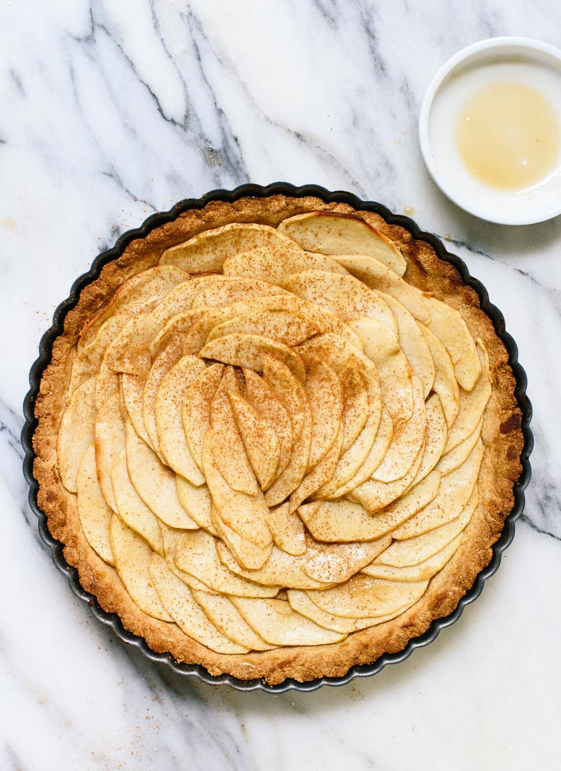 This delicious apple tart features an easy crust made with almond and oat flour. It's gluten free and easily made vegan/dairy free, too! cookieandkate.com