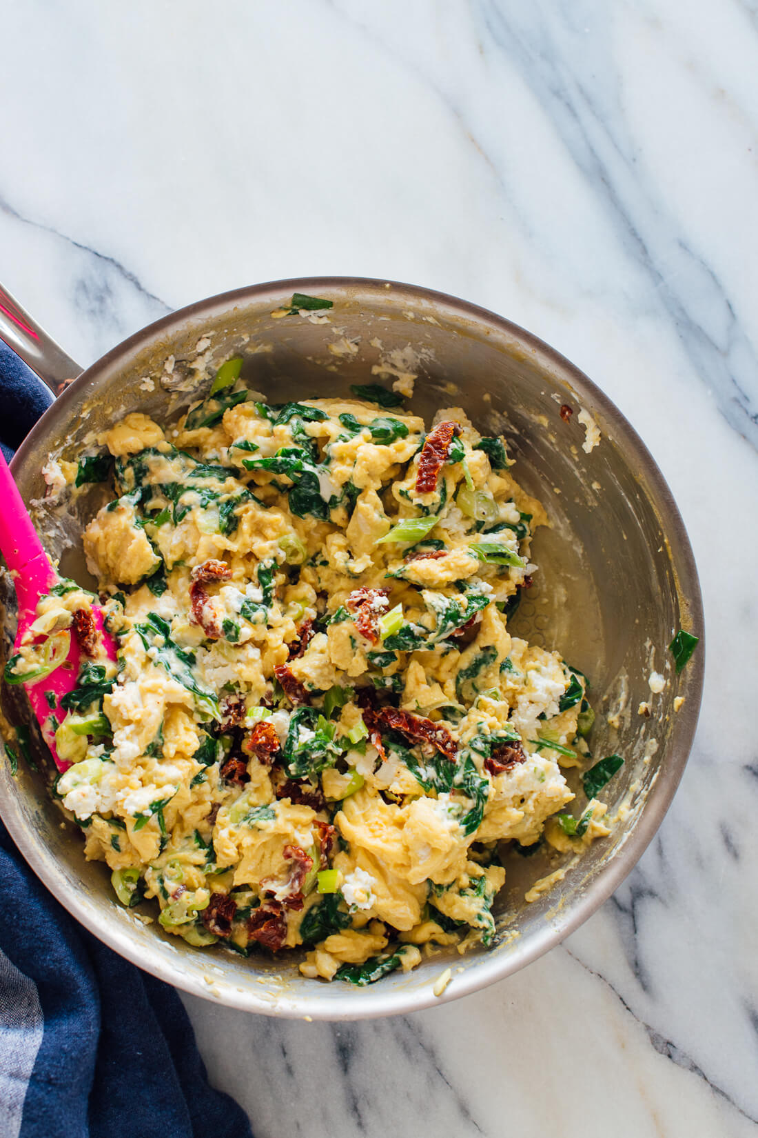 goat cheese spinach scrambled eggs in skillet