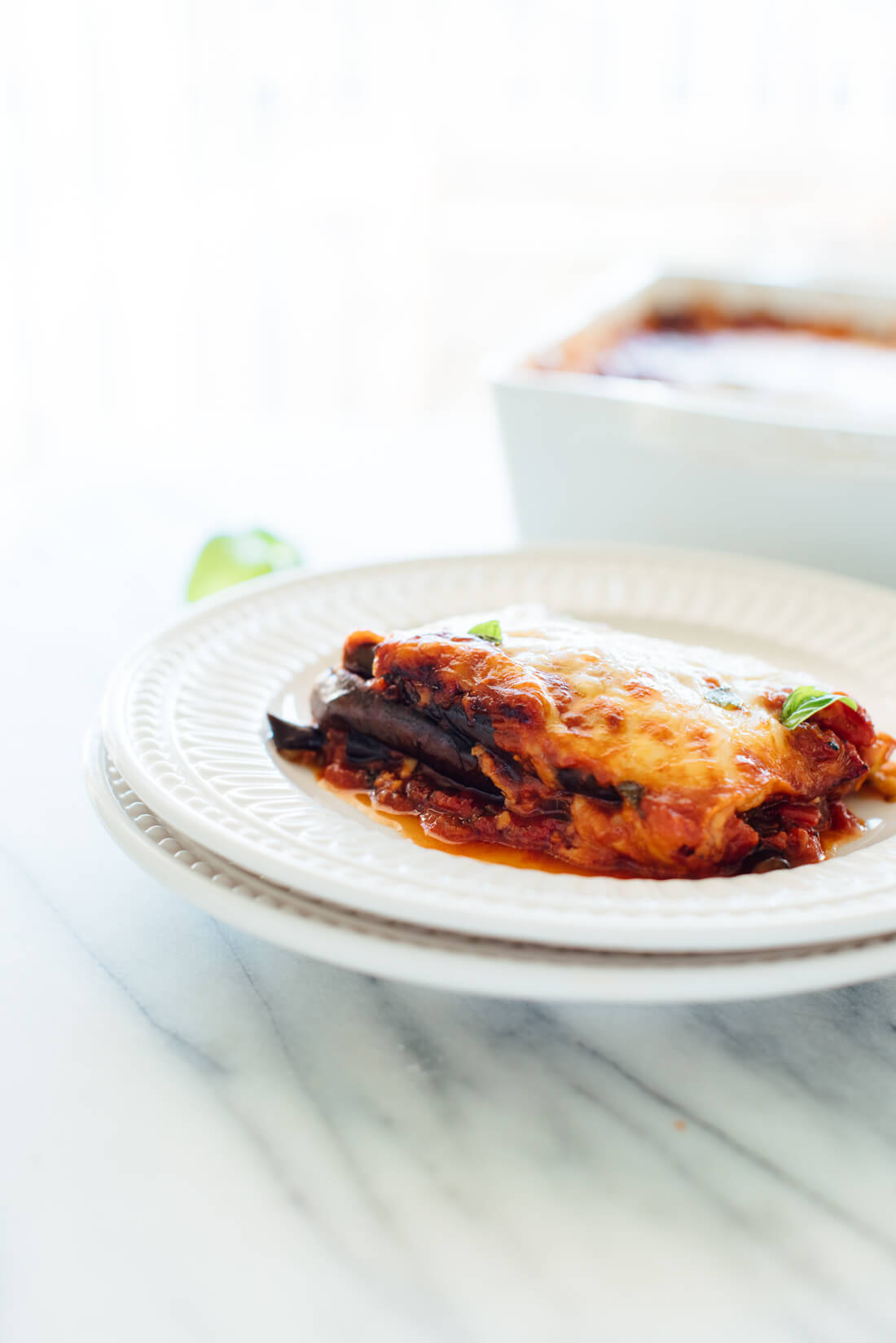 This Italian eggplant Parmesan recipe is lighter than most—it's made with roasted eggplant slices (not fried) and no breading (you won't miss it). #vegetarian