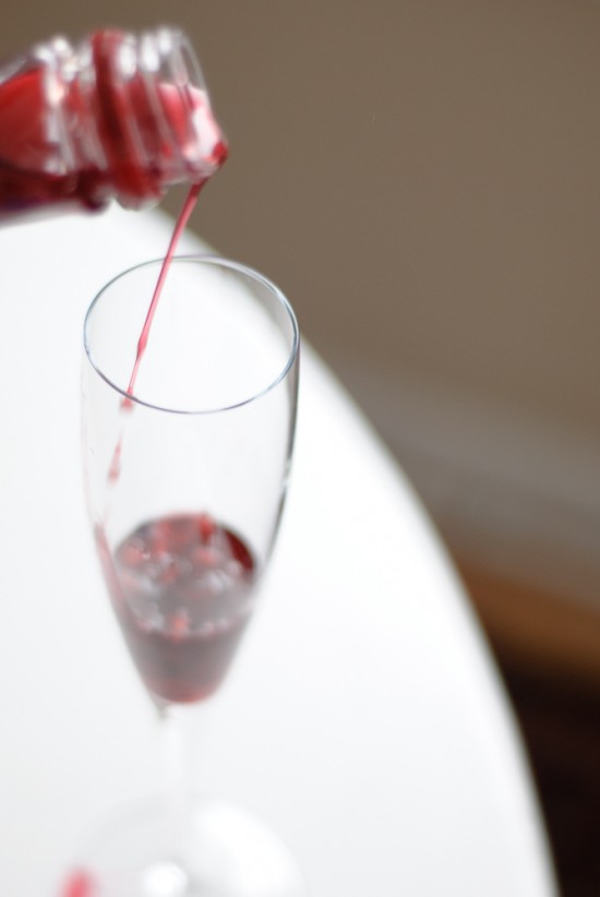 Pouring pomegranate juice into champagne glass