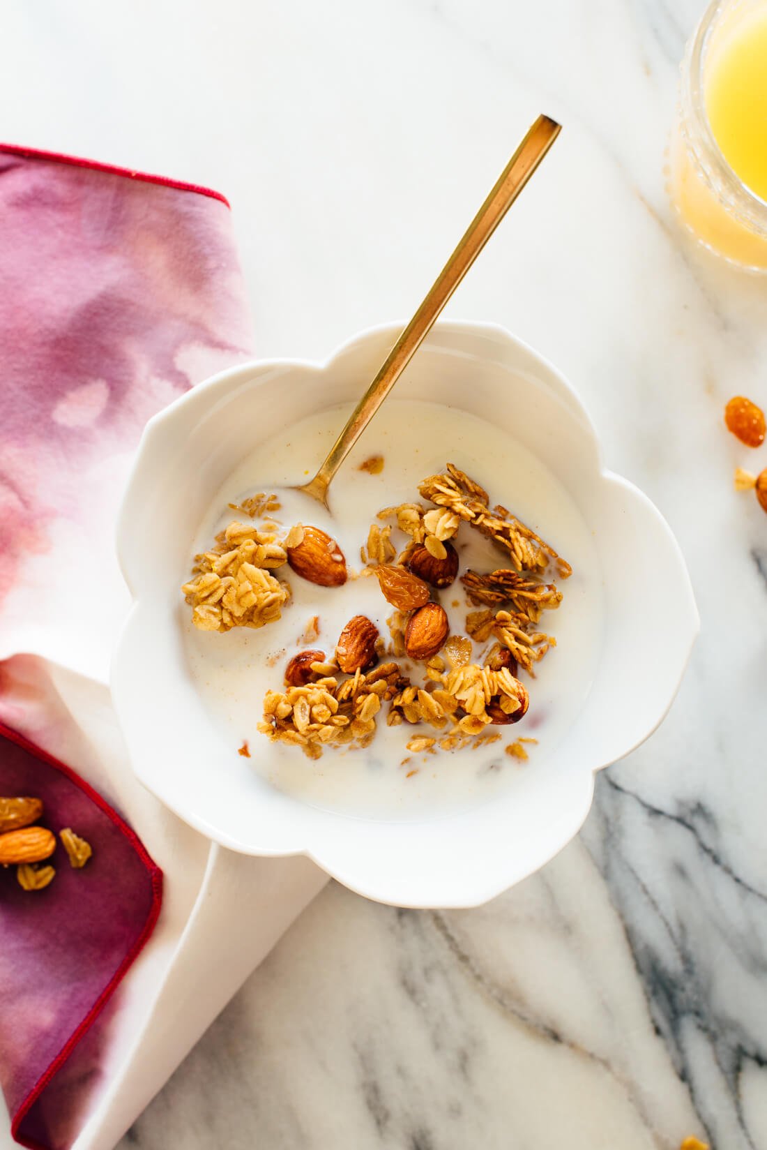 Orange almond granola in cereal bowl with milk