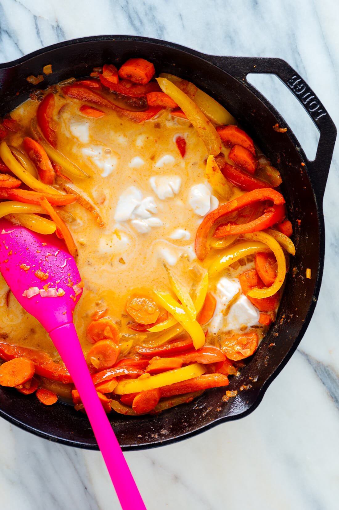 pouring coconut milk into panang curry