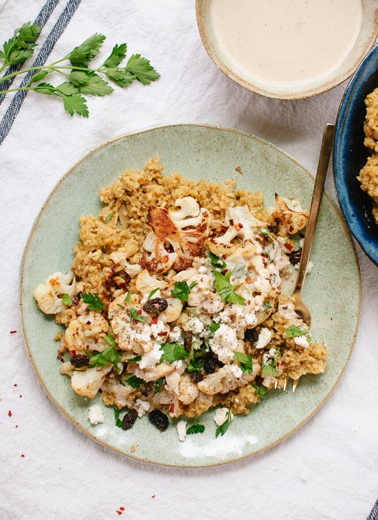 My new favorite meal: roasted cauliflower on a bed of healthy cracked freekeh pilaf, topped with tahini sauce, fresh parsley and raisins! cookieandkate.com