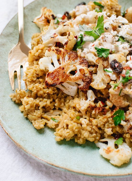 Roasted cauliflower on a bed of cracked freekeh, topped with an irresistible tahini sauce, fresh parsley and raisins - cookieandkate.com