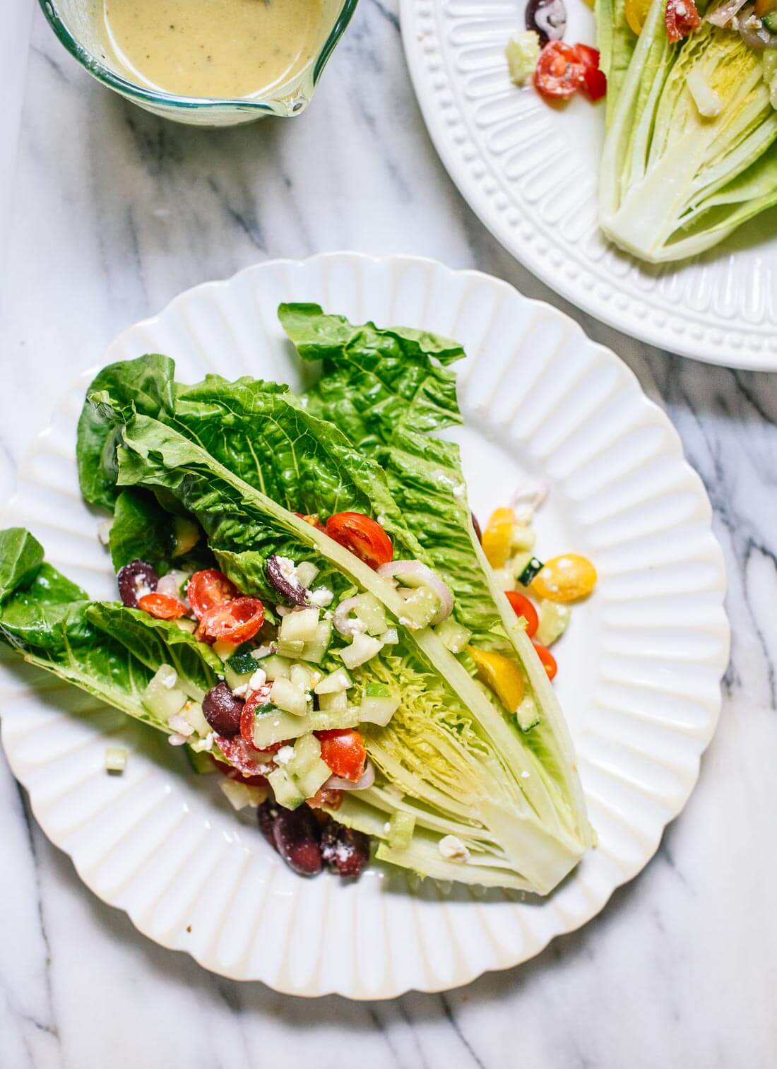 Romaine wedge salad with tomatoes, olives and feta piled on top! cookieandkate.com