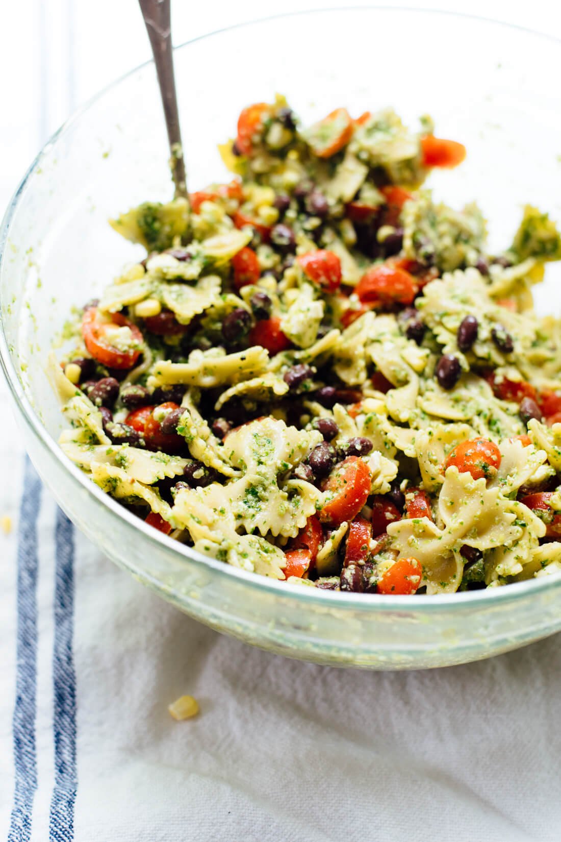 Healthy summer pasta salad with tomatoes, corn, black beans and a bold herbed pesto